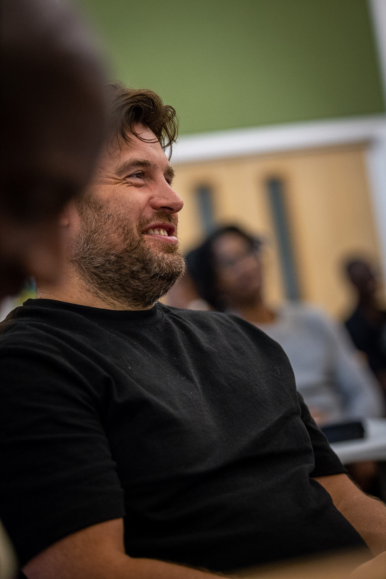 A man laughing during conversation with other men