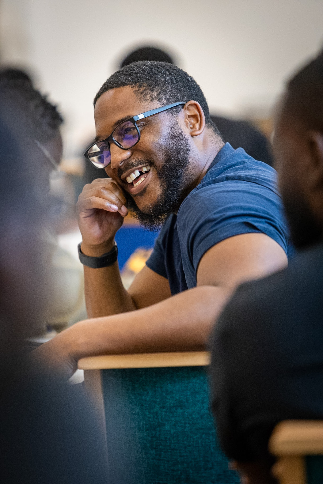 A man laughing and enjoying conversation with other men at Made for Dominion